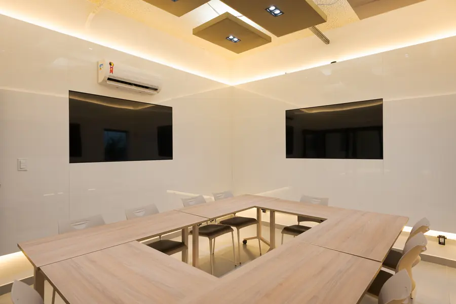 Sala foco com mesas em U para grupos pequenos